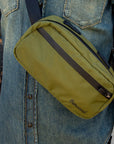Crossbody Bag von Thousand in Oliv getragen von Mann mit Jeanshemd und Tattoos
