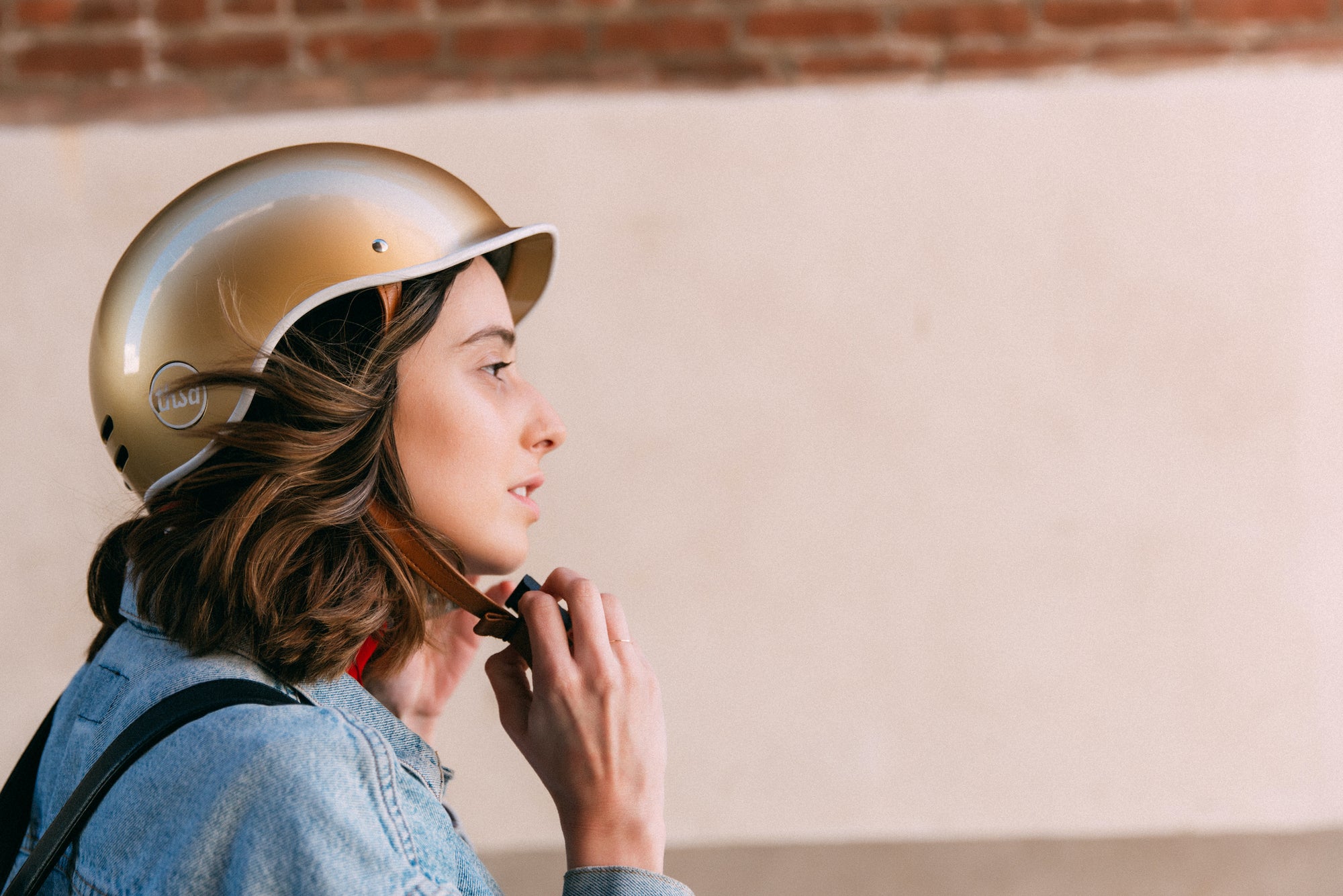 Frau schliesst ihren Fahrradhelm Thousand Gold aus dem Allthatiwant Shop