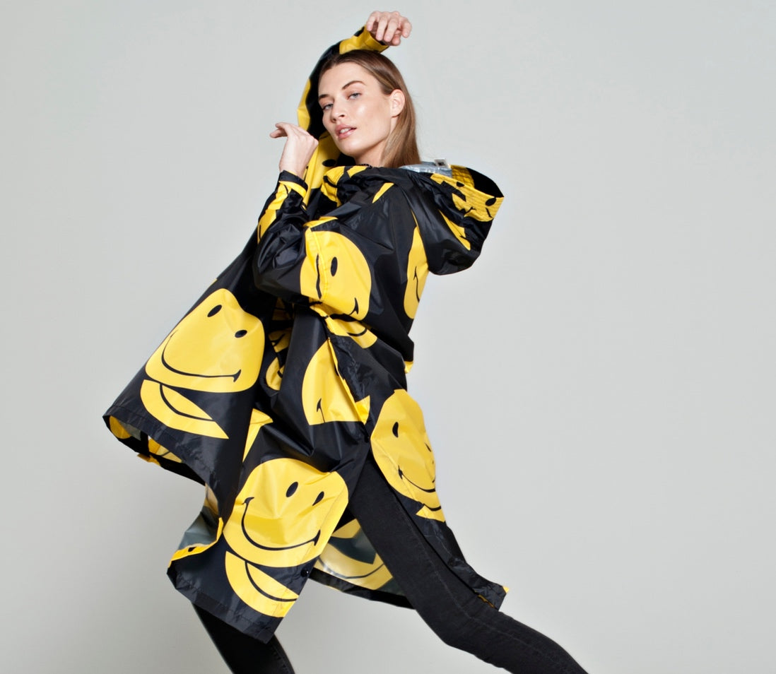 Rainkiss All Smiley Regenponcho mit gelben Smileys auf schwarzem Mantel
