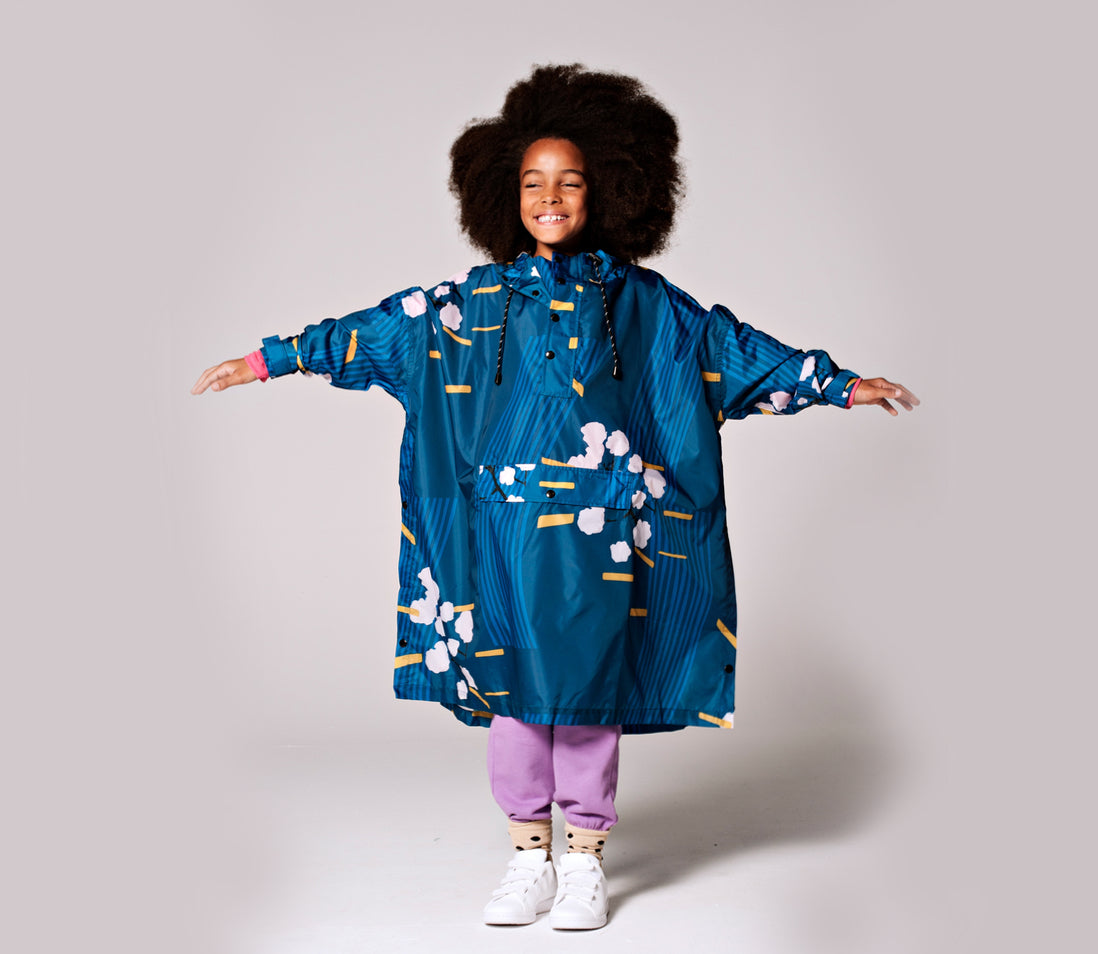 Rainkiss Blossom Regen Poncho Kinder vorne Kind mit ausgestreckten Armen