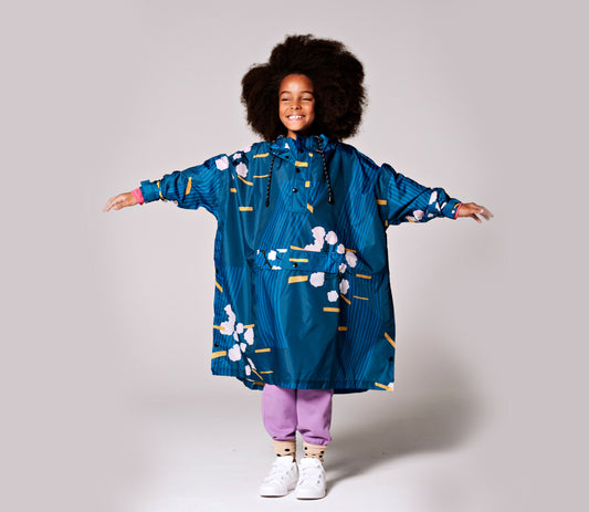 Rainkiss Blossom Regen Poncho Kinder vorne Kind mit ausgestreckten Armen